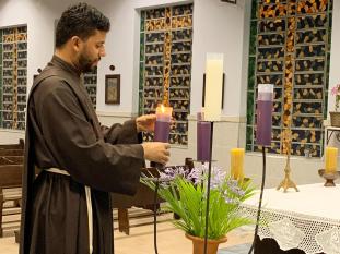 Brother Acacio lights altar candles.